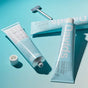 Three light blue tubes of Davids Premium Toothpaste - Whitening + Antiplaque and a metal tube key sit on a blue surface. One EWG Verified, fluoride-free toothpaste tube is open with its cap nearby, while the others are closed and positioned at different angles.