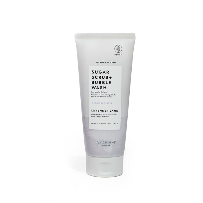 A white tube labeled Sugar Scrub + Bubble Wash for scalp and body in the scent Lavender Land by VOESH New York. The packaging highlights its vegan formula and features purple and black text.