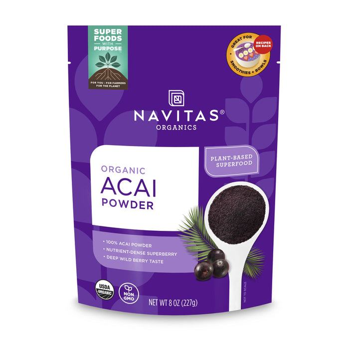 A purple bag of Navitas Organics Organic Acai Powder, featuring a white spoon filled with acai powder and berries. Labels highlight it as plant-based, USDA organic, non-GMO, and nutrient-dense. Net weight: 8 oz (227 g).