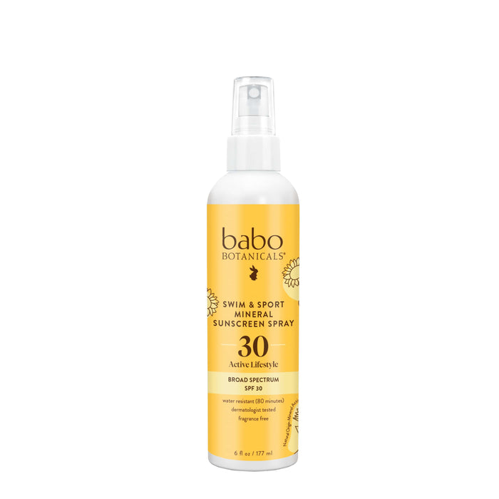 A yellow and white bottle of Babo Botanicals Swim & Sport Mineral Sunscreen Spray SPF 30, 6 fl oz, with a spray nozzle and floral graphics on the label.