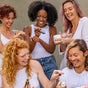 Five people joyfully share skincare products for sensitive skin, wearing casual light-colored clothes. Two use serum droppers, and another holds a Tree To Tub Sulfate Free Hydrating Face Wash for Dry Skin. Smiling warmly, they interact against a neutral background.