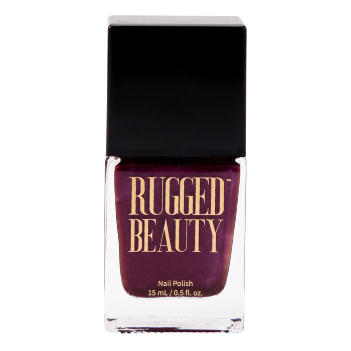 A bottle of Rugged Beauty nail polish with a deep burgundy color and a black cap. The label in gold letters reads Rugged Beauty and the bottle contains 15 mL (0.5 fl. oz.) of nail polish.