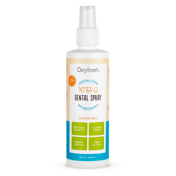 A bottle of Oxyfresh Dental Spray for pets, flavor free, 8 oz size. The label highlights benefits: freshens breath, cleans teeth, fights tartar, and fast acting. The bottle has a white spray cap.
