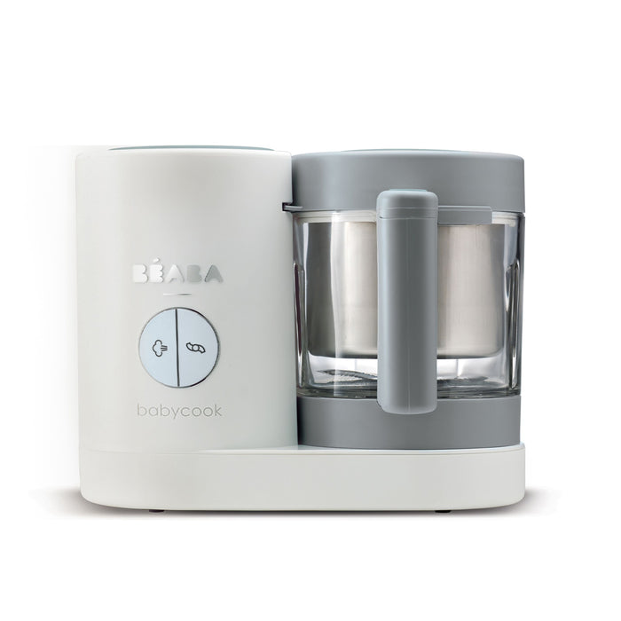 A white and gray BEABA Babycook machine with a large round button and a transparent blending container, designed for making baby food.