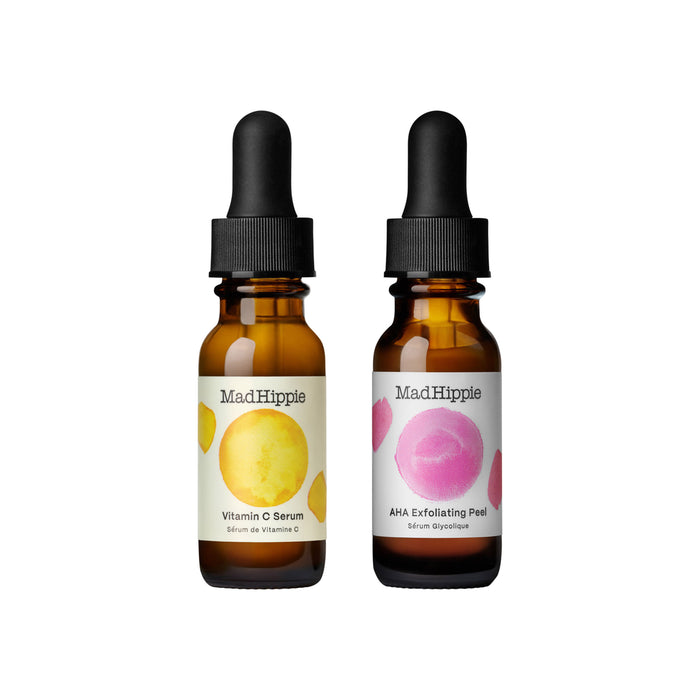 Two amber dropper bottles labeled Mad Hippie. The left bottle is Vitamin C Serum with a yellow circle, and the right is AHA Exfoliating Peel with a pink circle. Both bottles have black caps and white labels.