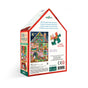 Back of a Christmas House 100 Piece Puzzle box by eeBoo Piece & Love, house-shaped with festive holiday art. Includes 100 pieces, finished size 14 x 10 inches—great for holiday family fun. Actual jigsaw piece shown.