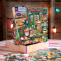 The Holiday Bakery 1000 Piece Puzzle by eeBoo Piece & Love features a festive bakery scene on a striped box, surrounded by treats and colorful string lights.