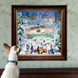A dog gazes at the New York City Skaters 1000 Piece Puzzle by eeBoo Piece & Love, showing people ice skating in snowy Central Park with skyscrapers behind, framed on a floral wallpapered wall.