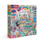 The eeBoo Piece & Love Sweet Shoppe 1000 Piece Puzzle features a vibrant sweet shop scene with candies, cakes, and treats. The colorful box displays jars, lollipops, and ice cream on recycled board labeled “Confectioners.”.