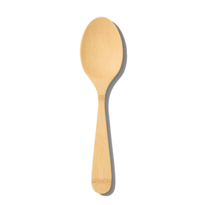 The Grove Co. Bamboo Serving Spoon, made from FSC-certified bamboo and boasting a smooth finish, is elegantly displayed against a white background with a soft shadow to its right, emphasizing its eco-friendly charm.