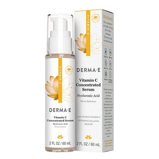A bottle of Derma E Vitamin C Concentrated Serum with Hyaluronic Acid is shown next to its packaging box. The bottle and box are white and gold with a pump dispenser and lotus flower design. Size: 2 fl oz / 60 mL.
