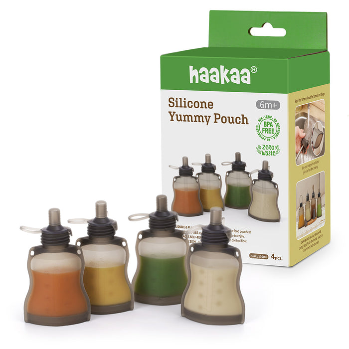 Four silicone food pouches filled with different colored purees are shown in front of a Haakaa Silicone Yummy Pouch box, which is labeled BPA free and suitable for ages 6 months and up.