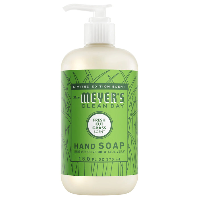 A bottle of Mrs. Meyer's Hand Soap with a pump features a green label with grass graphics, reading Fresh Cut Grass Scent, Hand Soap, and 12.5 fl oz (370 mL), highlighting its garden-inspired fragrance.