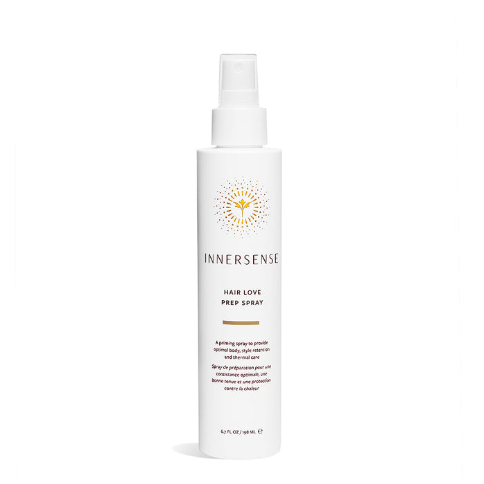 A white spray bottle of Innersense Hair Love Prep Spray with a yellow sunburst logo and black text on the front, photographed against a white background.