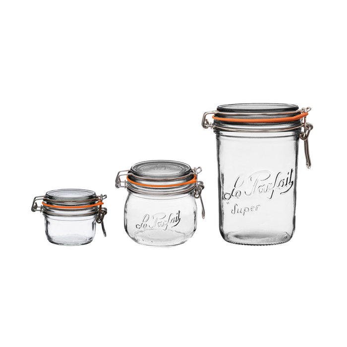 The Le Parfait Glass Jar Storage Starter Set includes three clear jars with orange seals and metal clasps, arranged from smallest to largest with decorative writing. Ideal for canning, each jar holds up to 1L of your favorite treats.