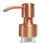 Close-up of a metallic rose gold pump dispenser on top of a clear bottle, against a white background.