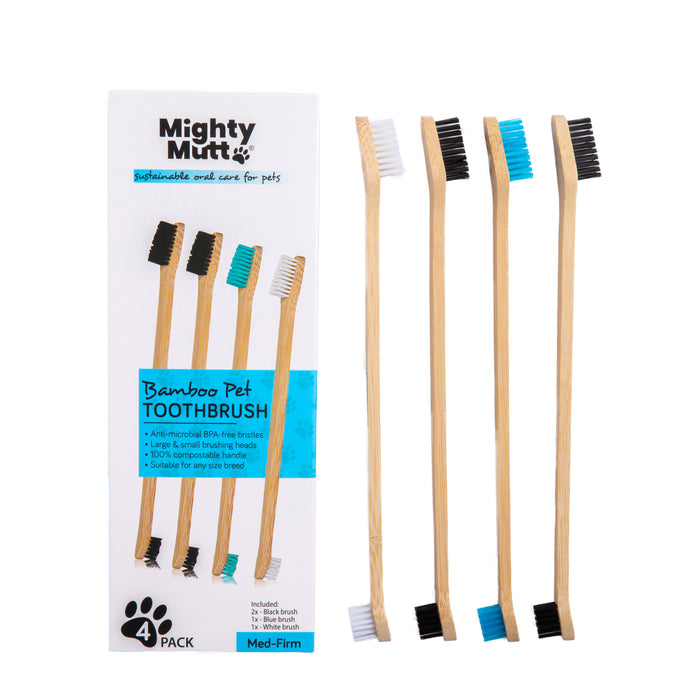 A box labeled Mighty Mutt Bamboo Pet Toothbrush with four bamboo toothbrushes beside it. Each toothbrush has a different colored bristle tip: white, black, blue, and mixed colors. The packaging highlights eco-friendly features.