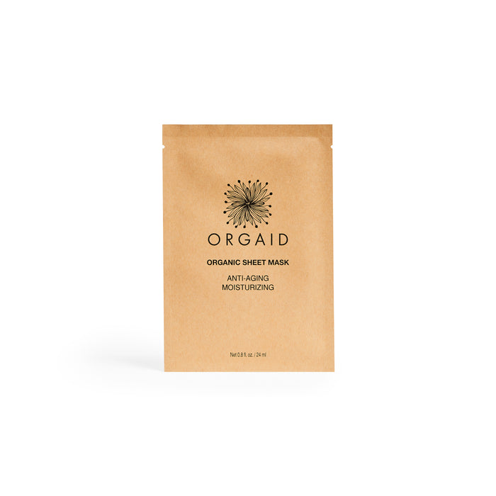 A tan packet of Orgaid Organic Sheet Mask with black text stating Anti-Aging Moisturizing is centered on a white background. The packet features a simple black floral logo above the brand name.