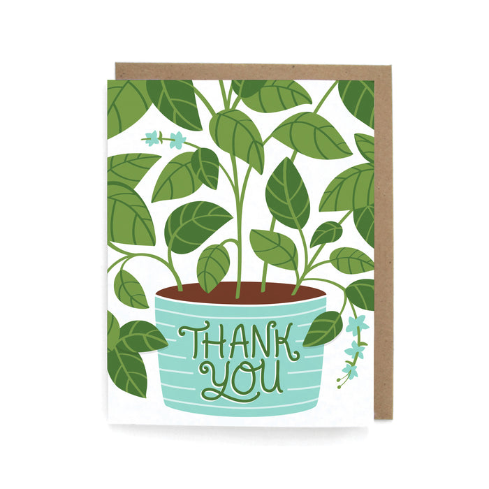 A greeting card featuring a leafy green plant in a blue-striped pot with the words THANK YOU written on the pot in decorative letters. The card is paired with a brown envelope.