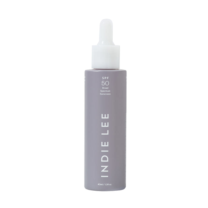 A lavender-colored bottle with a white dropper cap, labeled INDIE LEE vertically and SPF 50 Broad Spectrum Sunscreen near the top. The bottle holds 40ml or 1.3 fl oz of product.