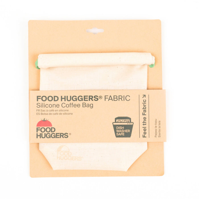 A silicone coffee bag in fabric packaging labeled Food Huggers Fabric Silicone Coffee Bag. The packaging notes it is dishwasher safe and includes a section to feel the fabric.