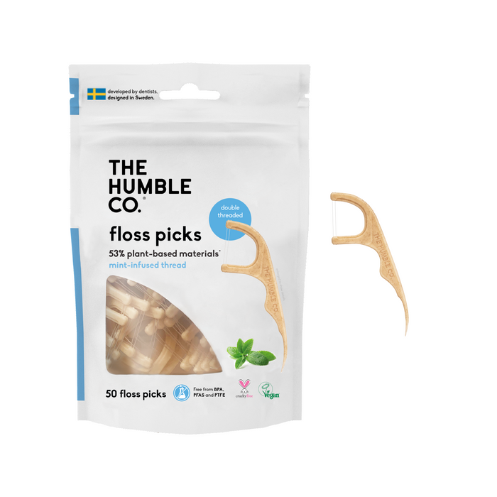 A package of The Humble Co. floss picks, labeled as 53% plant-based materials and mint-infused. One floss pick is shown outside the package. The package contains 50 double-threaded, vegan floss picks.