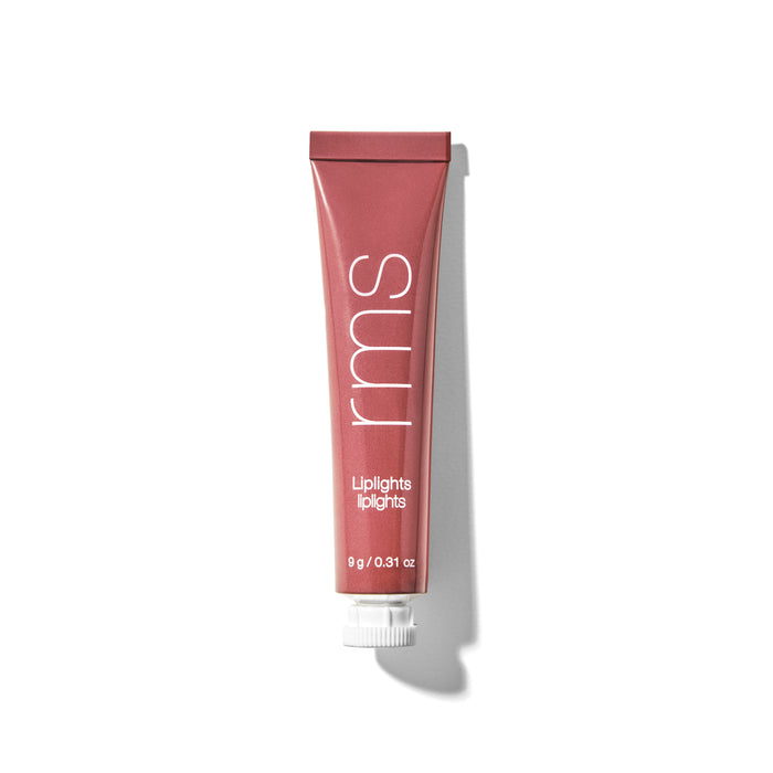 A red-pink tube labeled rms Liplights with a white cap, lying on a white background casting a shadow to the right. The tube contains 9g (0.31 oz) of product.