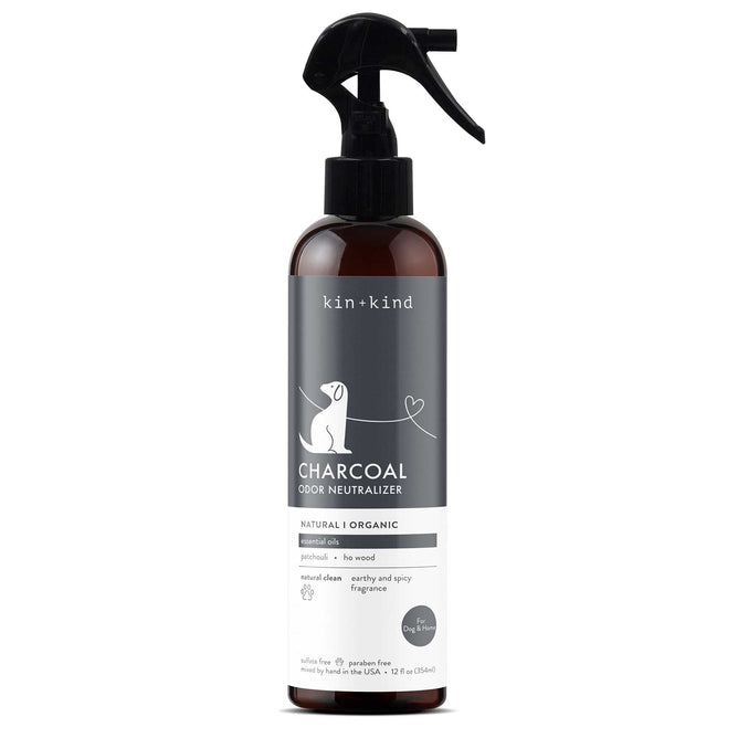 A bottle of kin+kind Charcoal Odor Neutralizer spray for dogs, featuring a black and white label with a dog illustration and a spray nozzle on top. The product is natural, organic, and suitable for pets.