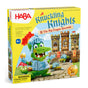 Front of the HABA Knuckling Knights 3D Board Game - Dragon Spectacle, for ages 4+, shows a smiling green dragon in knight armor before a castle. The playful yellow box features fun illustrations and a clear warning label.
