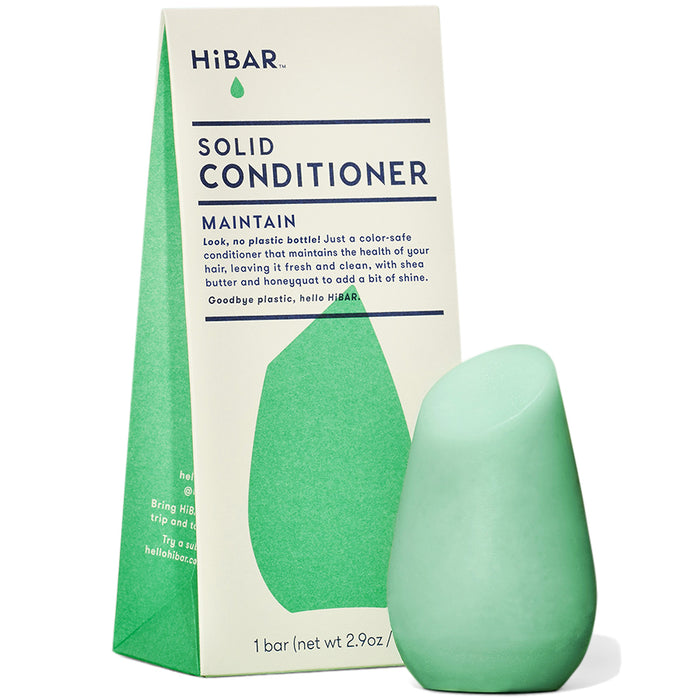 A green, teardrop-shaped solid conditioner bar stands in front of its matching green and cream packaging labeled HiBAR Solid Conditioner Maintain. Text on the box highlights its plastic-free and color-safe qualities.