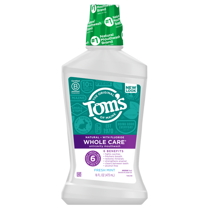 A bottle of Toms of Maine Whole Care mouthwash in Fresh Mint flavor, featuring a white and purple label, green cap, and highlighting fluoride and six oral health benefits.