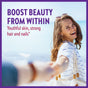 Smiling woman on a beach holding someones hand, turning back towards the camera. Text reads: Boost beauty from within. Youthful skin, strong hair and nails*.