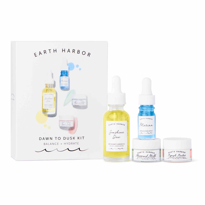 Earth Harbor Dawn to Dusk Kit featuring a box and four skincare products: two dropper bottles and two small jars, all labeled with pastel blue, yellow, and pink accents on a white background.
