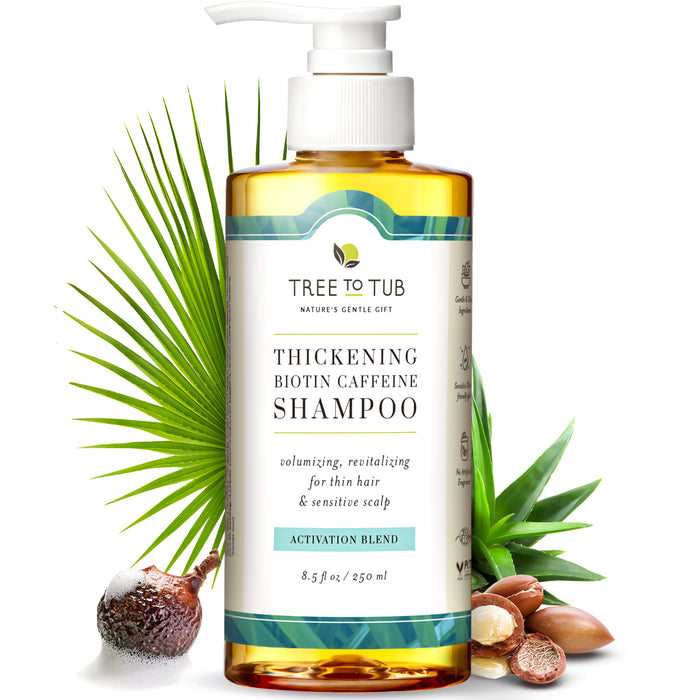 A bottle of Tree to Tub Thickening Biotin Caffeine Shampoo with a pump dispenser, surrounded by natural ingredients including soapberry, aloe vera, and argan nuts. The label highlights benefits for thin hair and sensitive scalp.