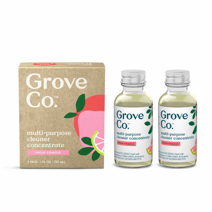 Two bottles of Grove Co. multi-purpose cleaner concentrate in Fresh Pomelo scent are next to a brown box with colorful pomelo illustrations and product branding.