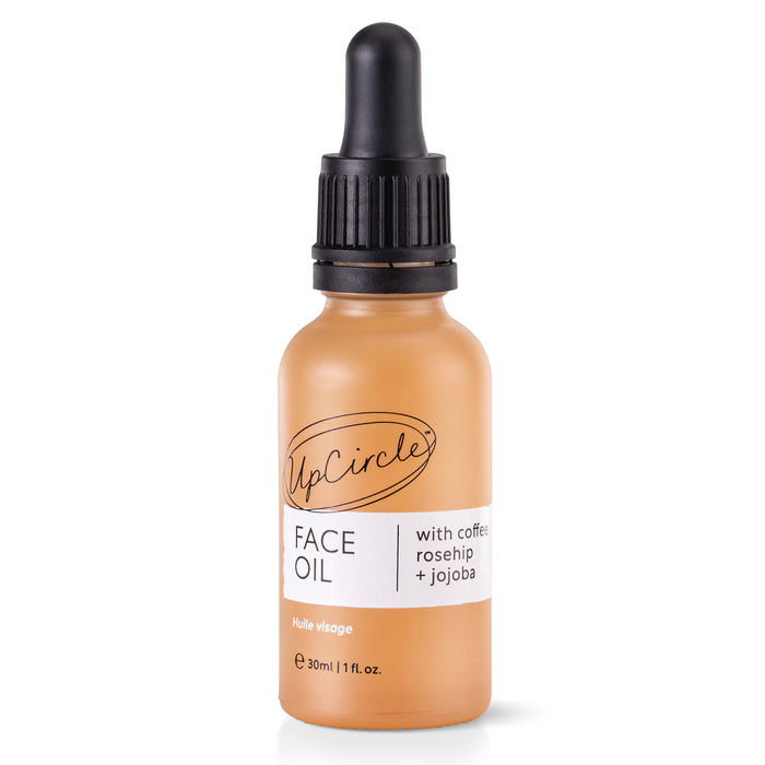 A small amber bottle of UpCircle Face Oil with a black dropper cap. The label reads UpCircle, FACE OIL, and with coffee, rosehip + jojoba. The bottle contains 30ml (1 fl. oz.) of product.