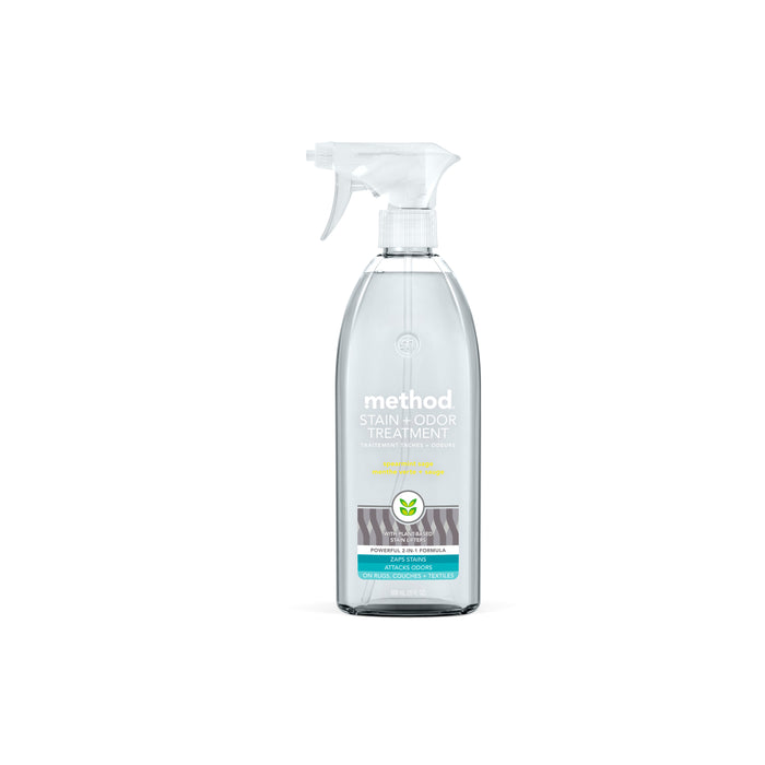 A clear spray bottle of Method Stain + Odor Treatment, featuring a white spray nozzle and a label with teal and gray accents, placed on a white background.
