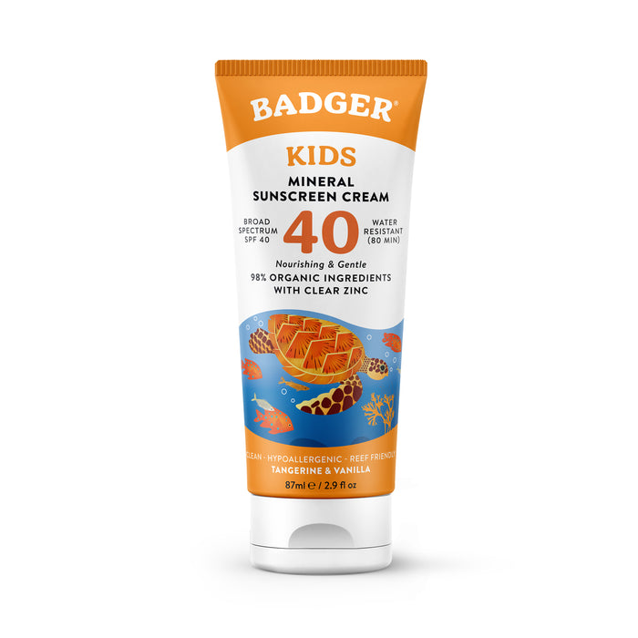 A tube of Badger Kids Mineral Sunscreen Cream SPF 40 featuring an illustration of a honeycomb and underwater scene with fish. The tube highlights that it is water resistant and made with organic ingredients and clear zinc.