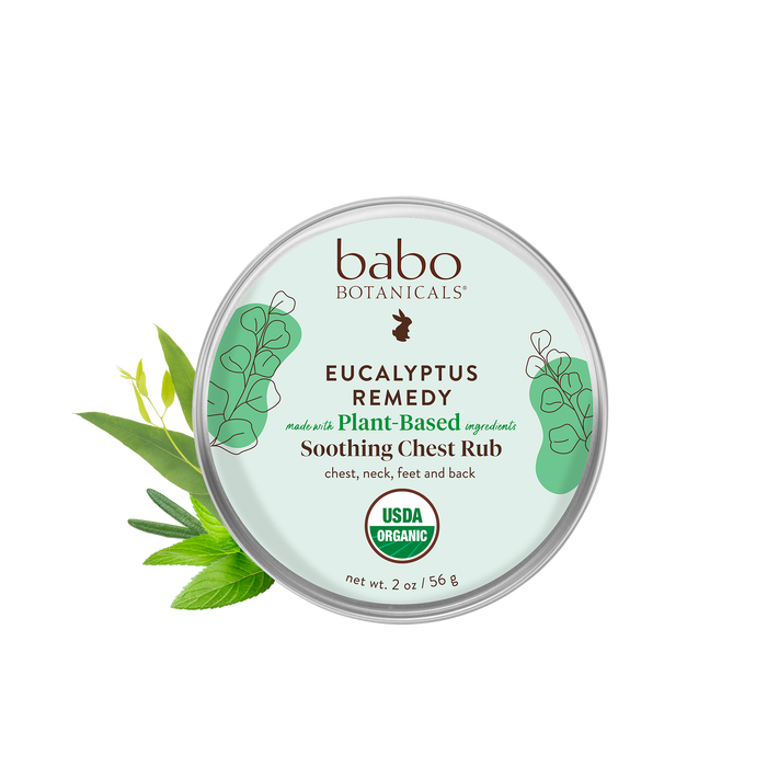 A round tin of Babo Botanicals Eucalyptus Remedy Soothing Chest Rub with plant illustrations, USDA organic seal, and text describing it as plant-based and for chest, neck, feet, and back. Net weight is 2 oz (56 g).