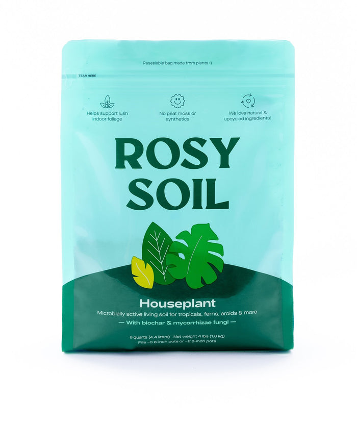 A teal and green bag labeled Rosy Soil Houseplant featuring leaf illustrations and icons highlighting benefits like natural ingredients and support for lush indoor foliage. The bag is resealable and designed for houseplants.