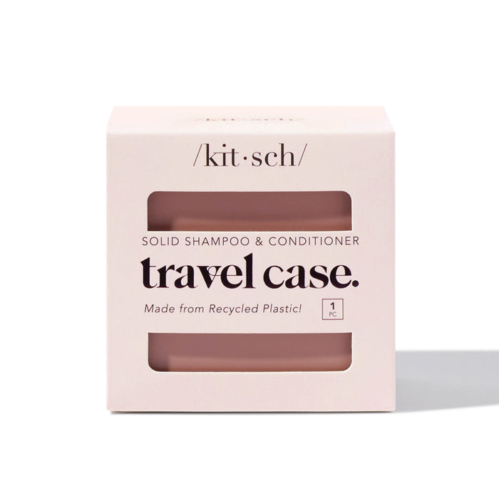 A pale pink box labeled kitsch solid shampoo & conditioner travel case, featuring a window showing the product inside. The packaging notes it is made from recycled plastic and contains one piece.