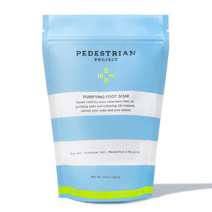 A blue and white resealable bag labeled Pedestrian Project Purifying Foot Soak with text describing the products benefits and ingredients like Epsom salt, Himalayan salt, meadowfoam, and marula oil.