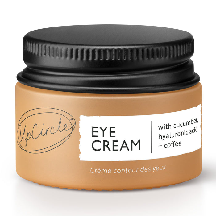 A small jar of UpCircle Eye Cream with a black lid and a tan label, featuring text that highlights cucumber, hyaluronic acid, and coffee as key ingredients.