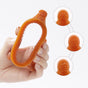 A hand holds an orange, oval-shaped silicone teething toy with textured knobs. Three close-up insets show different textured patterns on the toys surface. The background is white.