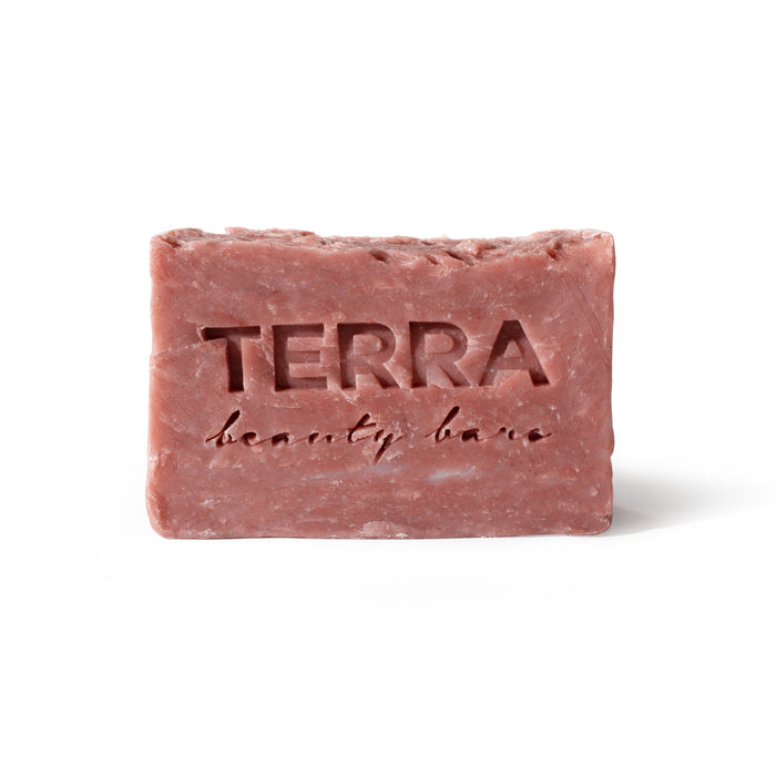 A rectangular pink soap bar with the words TERRA beauty bars engraved on the front, displayed against a plain white background.