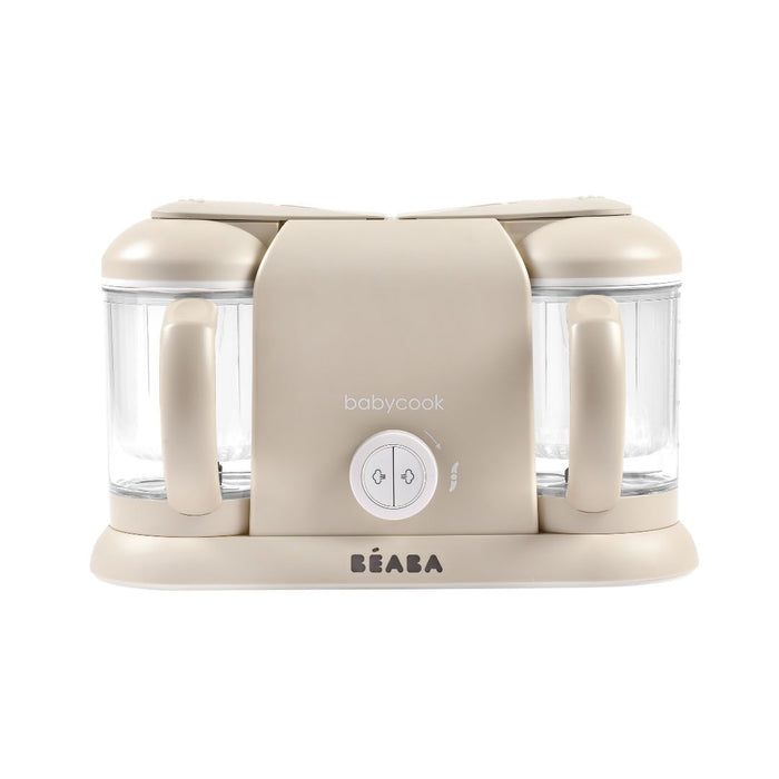 Beige BEABA Babycook appliance with two clear blending containers, labeled babycook and BEABA on the front, featuring a central control dial and handles on each side.