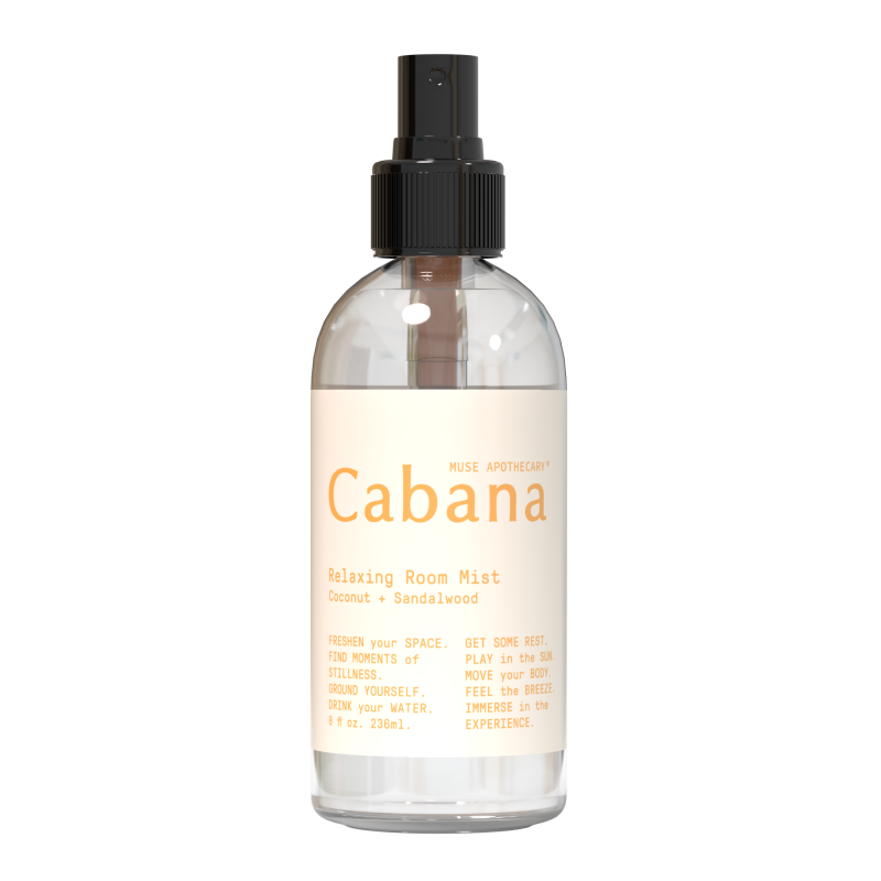 An 8 fl oz (236 ml) clear spray bottle labeled Relaxing Room Mist from Muse Apothecary, featuring a coconut and sandalwood aroma infused with essential oils. It has a black spray nozzle and a beige label that reads, Refresh your space... Feel the breeze.