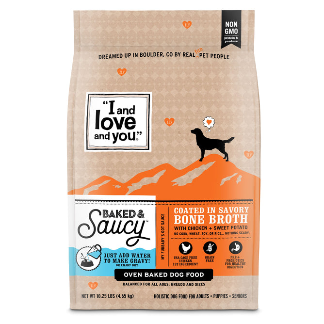 The I and Love and You Baked & Saucy w/ Chicken + Sweet Potato Kibble bag features a dog silhouette on an orange mountain design. It highlights being Coated in savory bone broth, Non-GMO, and made with USA farm-raised chicken. This grain-free dry dog food weighs 10 pounds.