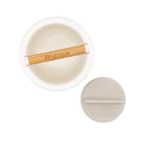 Top-down view of a white ceramic bowl with a wooden handle labeled full circle, next to a round, light gray silicone lid with a small handle.