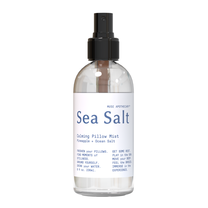 A clear spray bottle labeled Sea Salt Calming Pillow Mist with scents of pineapple and ocean salt. The label includes calming instructions and has a black spray nozzle against a plain light background.